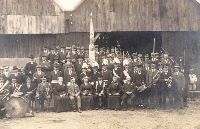 1924_Jansing.jpg - Schützenfest 1924 (auf dem Hof Eing oder Hof Hüning-Ubbenhorst?). Gruppenfoto der Schützen mit dem Königspaar Bernhard Jansing-Essling und Elisabeth Schulze Alfers nebst Throngefolge und Musikkapelle.